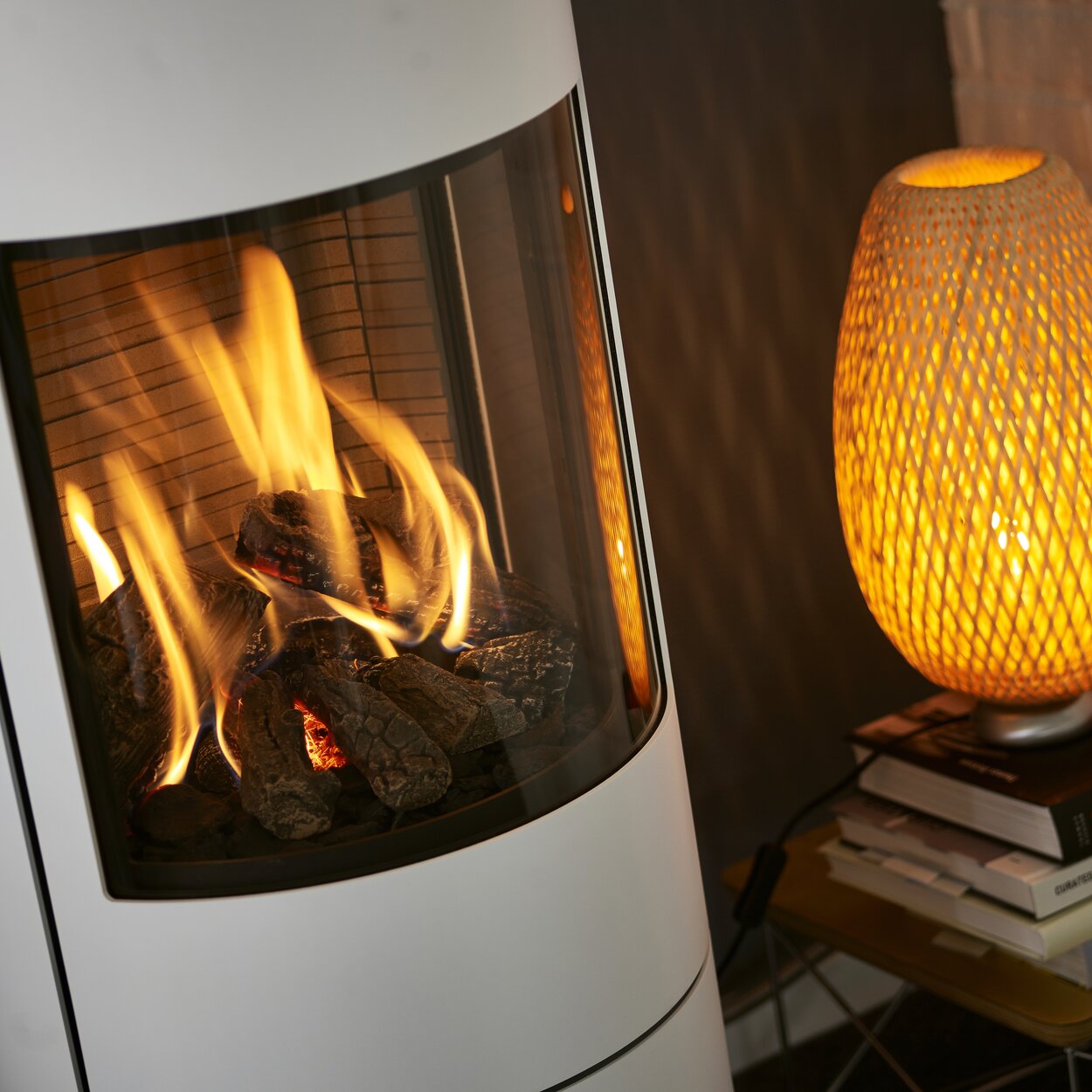 Firebox of the VIVA L gas stove in white with steel door and side windows and pleasantly burning gas flame