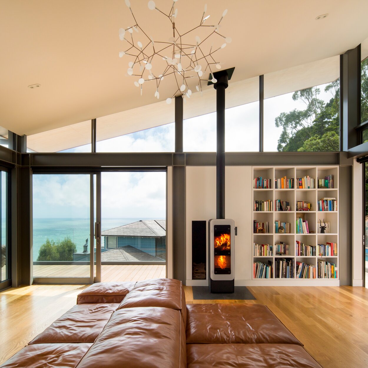 Wood stove bionic fire EVO in the colour black with white glass door in the living room by the sea