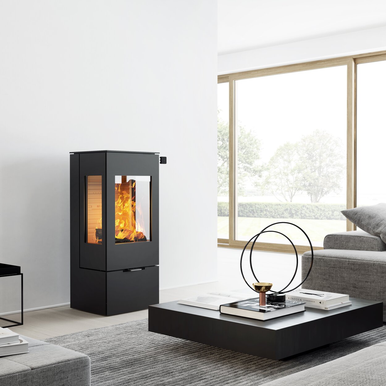 Wood stove NEXO 100 in black with steel door and two side windows in a modern, bright living room