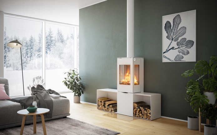 Wood stove NEXO 120 in white with steel door, two side windows and two side benches in front of a green wall in a decorative living area