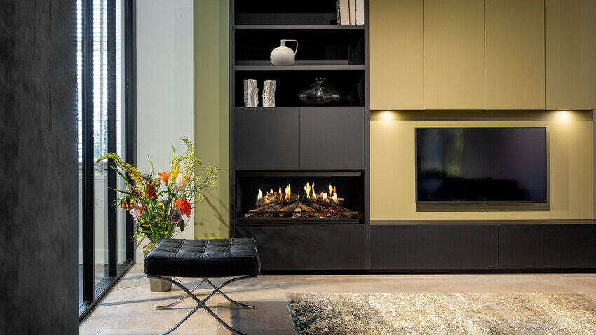 The E-One 100 Front electric fireplace in the living room as part of a green sideboard with integrated TV.