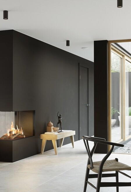 La cheminée à gaz VISIO 90 RD s'intègre idéalement comme séparateur de pièce dans un mur noir entre le salon et la salle à manger et structure l'espace de vie à la décoration sobre