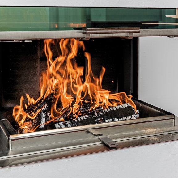 VISIO 3 ELEMENT mit geöffneter Feuerraumtüre, Holzscheiten und Luftschieber