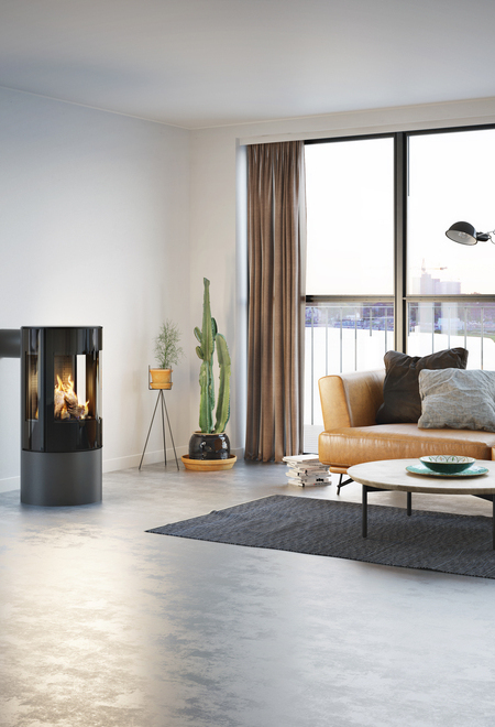 Poêle à gaz VIVA 100 L en platine avec porte de foyer plein verre dans un appartement minimaliste avec vue sur le skyline