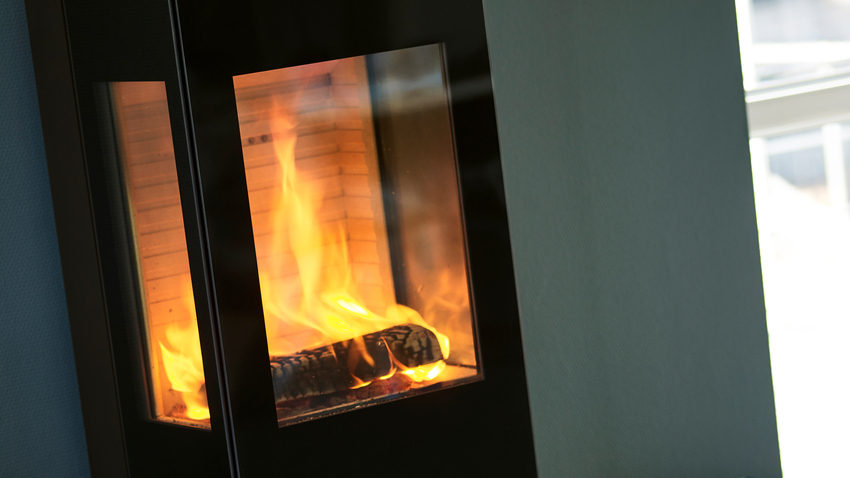 Wood stove NEXO 120 in black with glass door and two side windows with a direct view of the burning fire