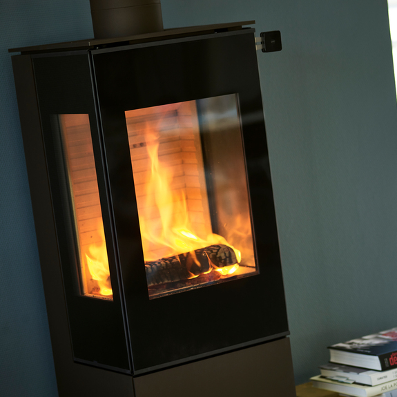 Poêle à bois NEXO 120 noir avec porte de foyer plein verre et deux vitres latérales offrant une vue directe sur le feu en combustion