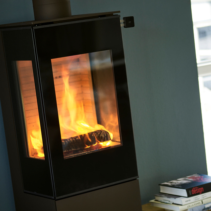 Wood stove NEXO 120 in black with glass door and two side windows with a direct view of the burning fire