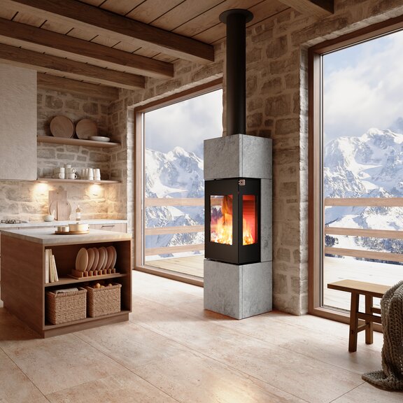 Stufa a legna NEXO 160 Pietra ollare in colore nero nel soggiorno con vista sulle montagne