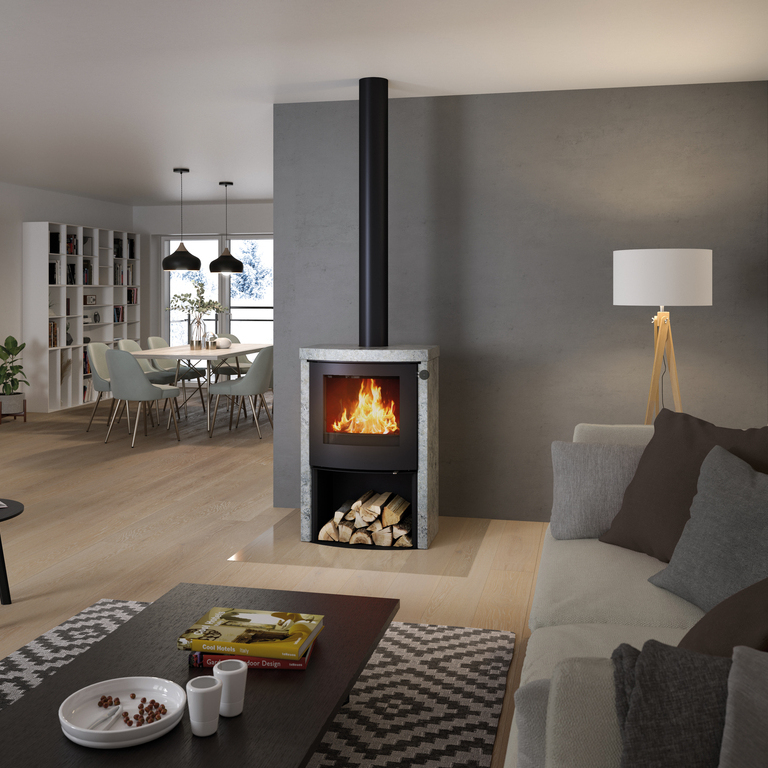 Wood stove Q-TEE 2 C Soapstone with steel door and wood compartment in the living room in various shades of grey
