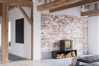 Stufa a legna Q-TEE 2 in nero con panche laterali in una casa rustica arredata in modo minimalista