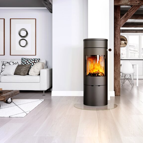  Holz-Kaminofen VIVA 120 L in Schwarz mit Stahltür in einer hellen, offenen Wohnung