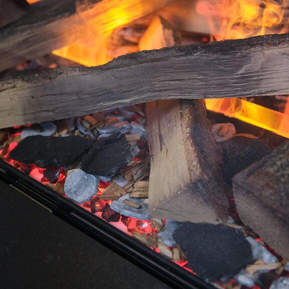 Primo piano della camera di combustione del caminetto elettrico e-MatriX con ciocchi di legno