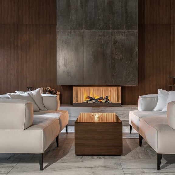 Feu électrique Cassette 400 LED avec incrustation de bois intégré dans un élément en béton dans un salon chic