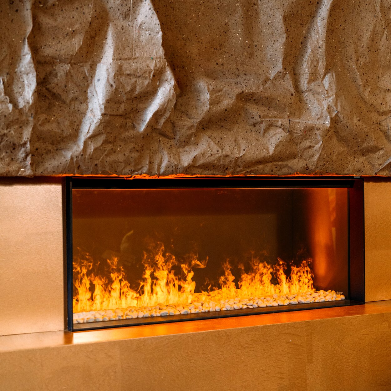 Electric fire e-Matrix Linear 1050/400 front on orange wall with stone elements