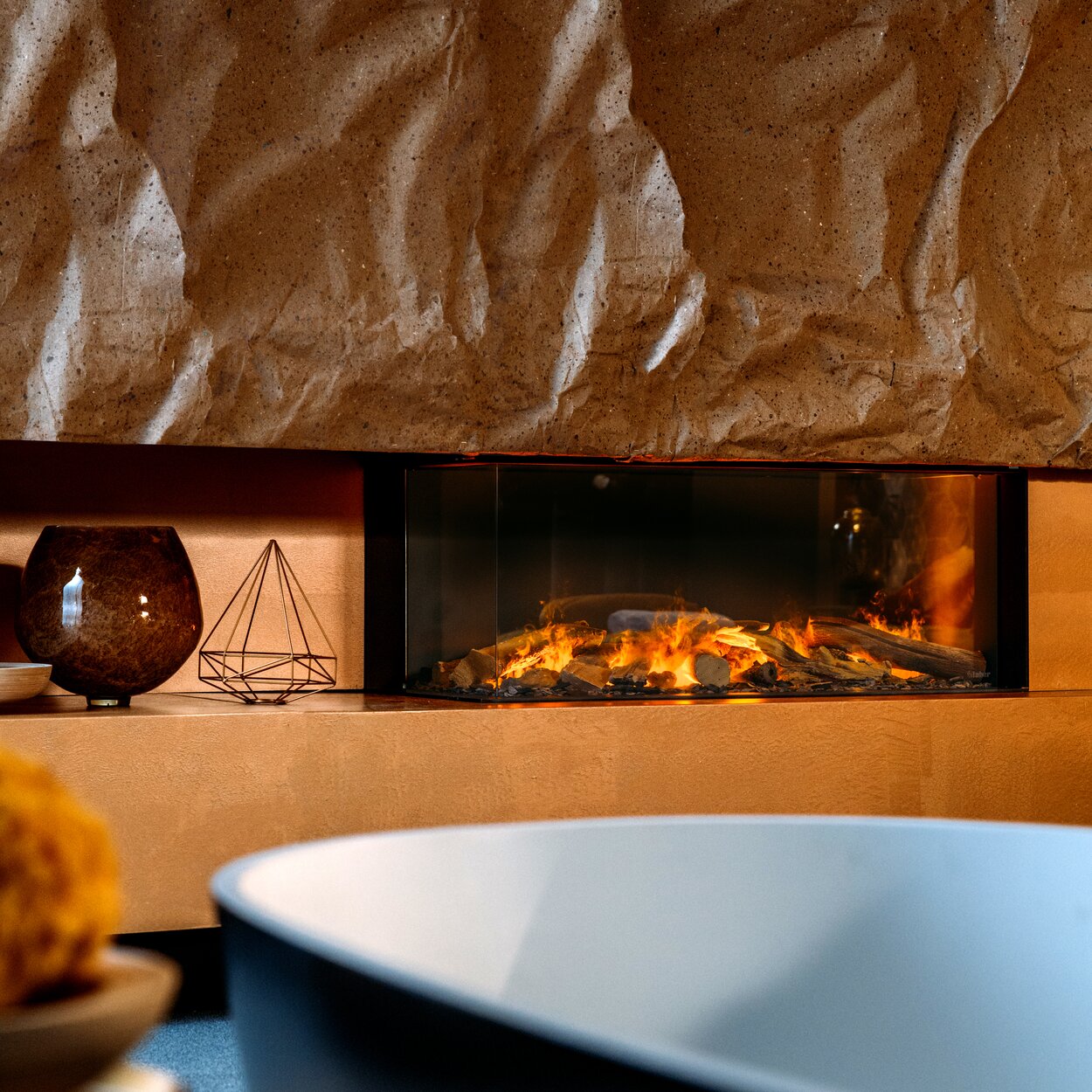 Corner version of the e-Matrix Linear 1050/400 electric fireplace in the bathroom on an orange wall with stone element