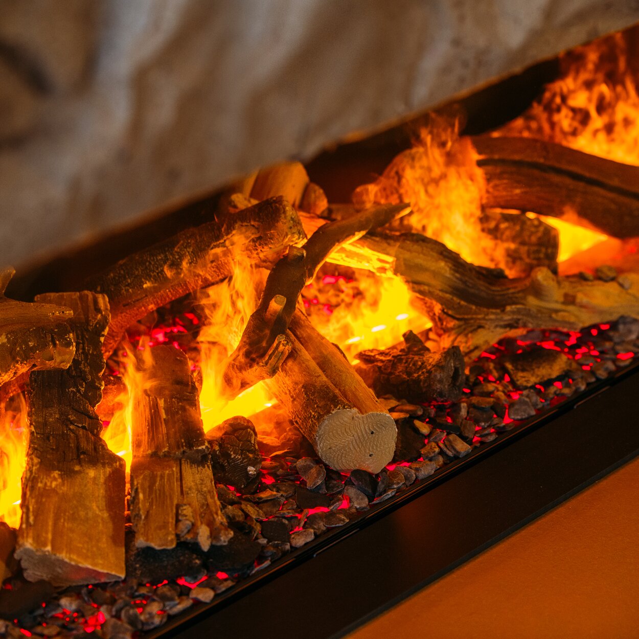 The wood logs and water vapour flames are illuminated with LED lamps to create an electric fire.