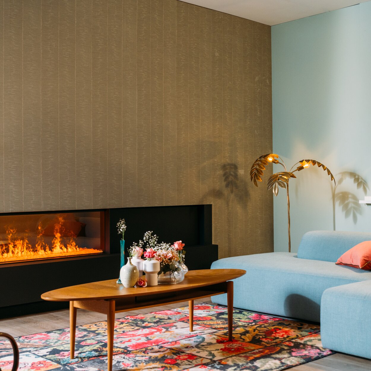Foyer électrique eMatriX Linear 1300/400 face dans un salon confortable avec des fleurs et un canapé bleu