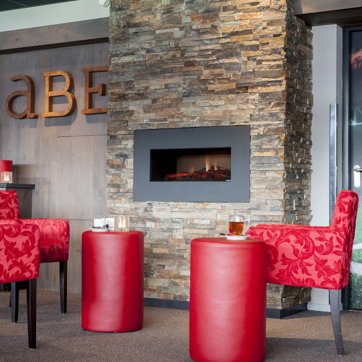 Opti-V-Single electric fire in the bar with red furniture built into a stone wall
