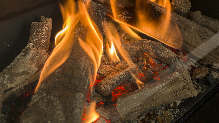 De belles flammes de gaz et d'authentiques bûches, y compris les braises, dans la cheminée à gaz MatriX 800/650 Face
