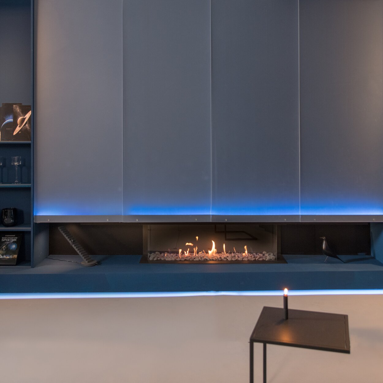 Dreiseitiger Gas-Kamin MatriX Linear 1300/400 von Faber im Wohnzimmer mit blauer Beleuchtung