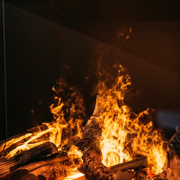 In the e-Matrix Mood 800/500 electric fireplace with 3-sided glazing, the ceramic wood logs and water vapour flames are illuminated with LEDs.