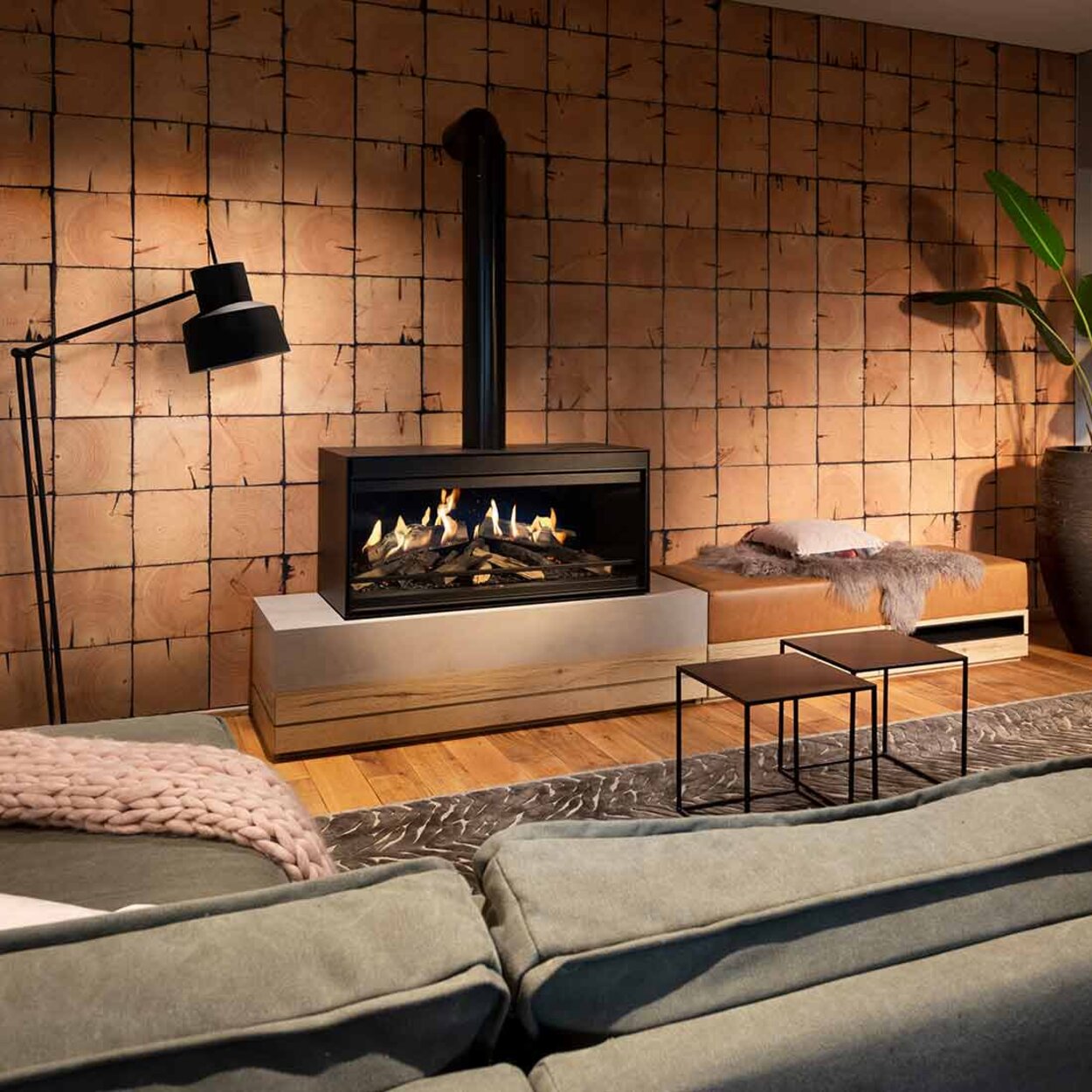 The free-standing electric fireplace E-One 100 Front in an industrial living room with a grey sofa.