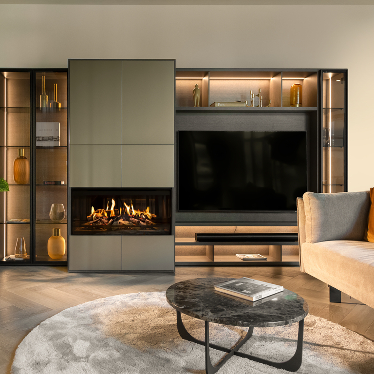 E-One 100 F electric fireplace installed in a modern wall unit with shelf and TV in a simple living room with sofa in brown tones