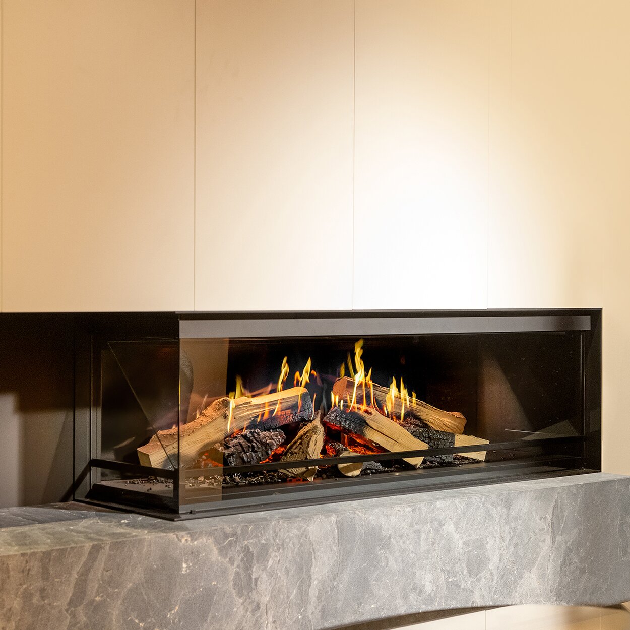 The 2-sided glazed electric fireplace E-One 130 C in a cosy living room with concrete element.