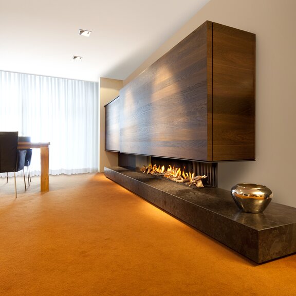 Gas-Kamin G165/37C Eckvariante mit Holzverkleidung im grosszügigen Esszimmer mit orangenem Boden