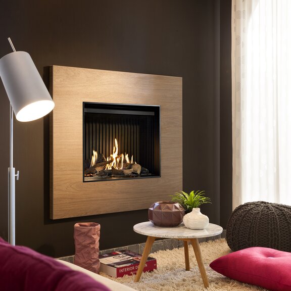 Gas fireplace G60/48F front version with wood surround on dark wall installed in the living room