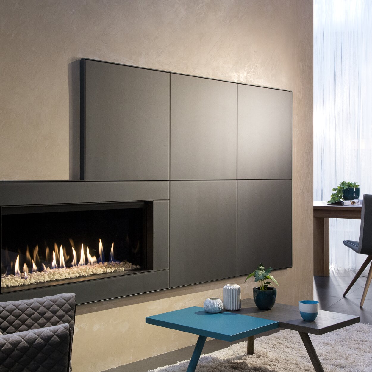 Gas fireplace G100/41F by Kalfire with white stones in the firebox in a built-in furniture element in a modern flat in copper colours