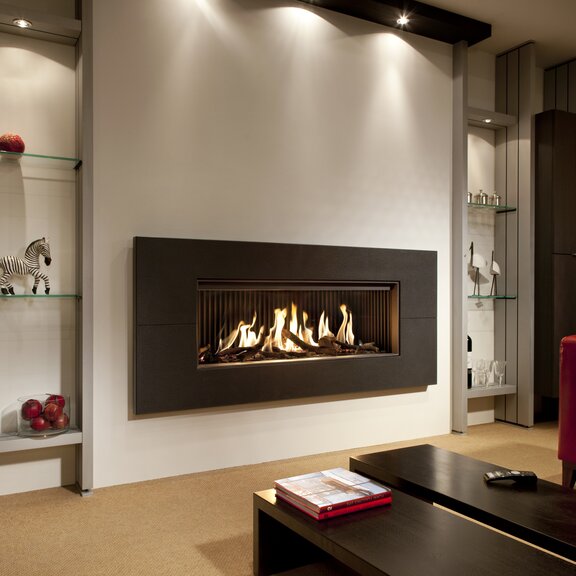 Gas-Kamin G120/41F mit schwarzer Umrahmung an heller Wand eingebaut im Wohnzimmer mit roten Akzenten