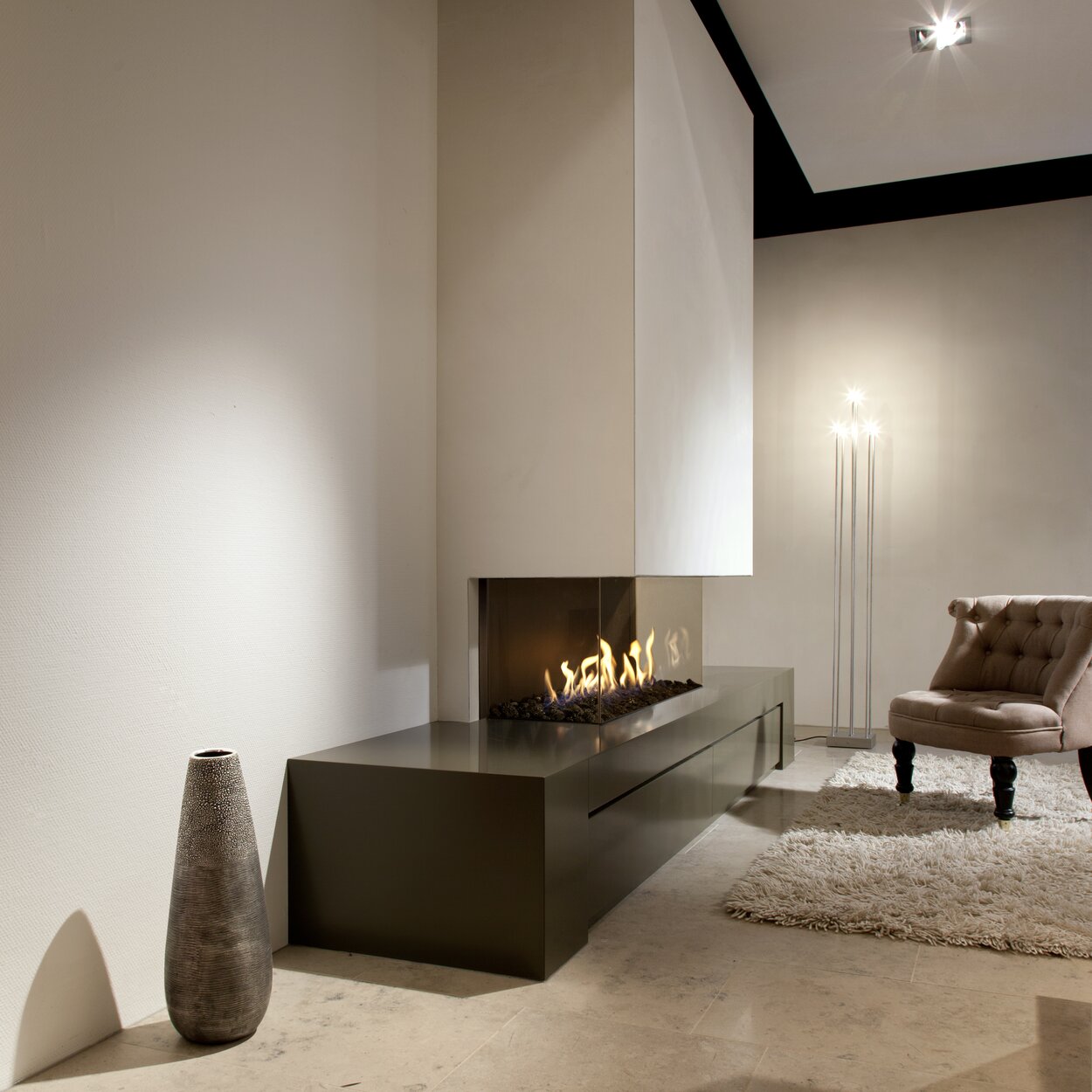 Gas fireplace G130/37S installed on a dark base unit with light-coloured cladding in a stylish living room