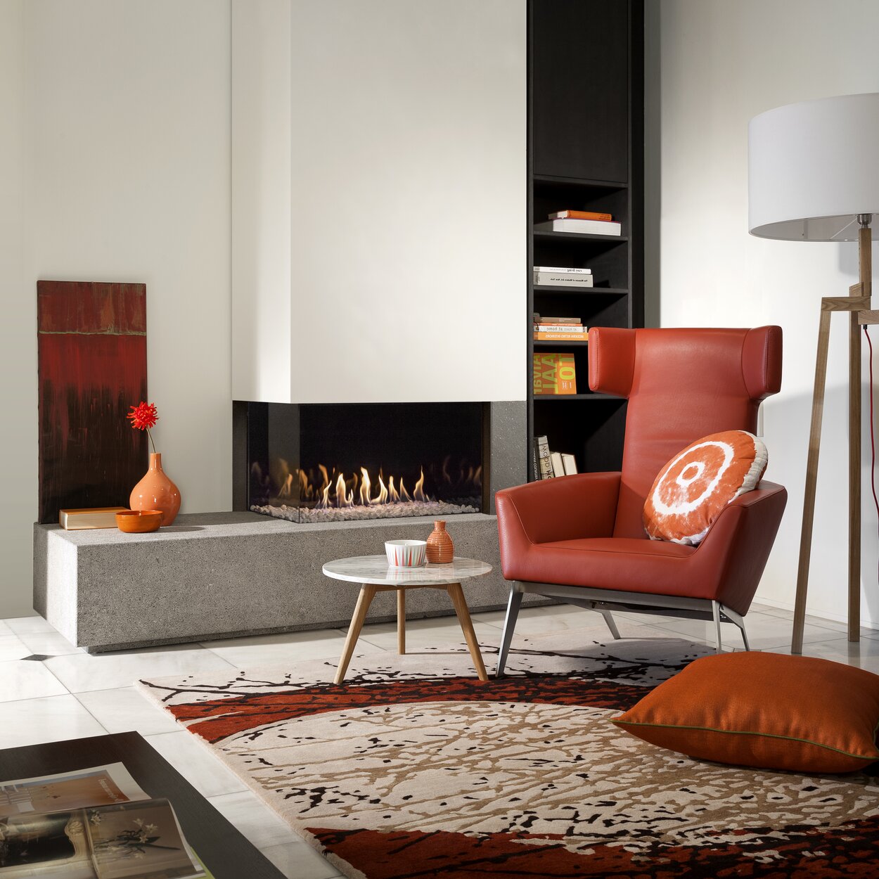Gas fireplace G85/44C corner version on a concrete base with white cladding in a modern living room with rust-coloured accents