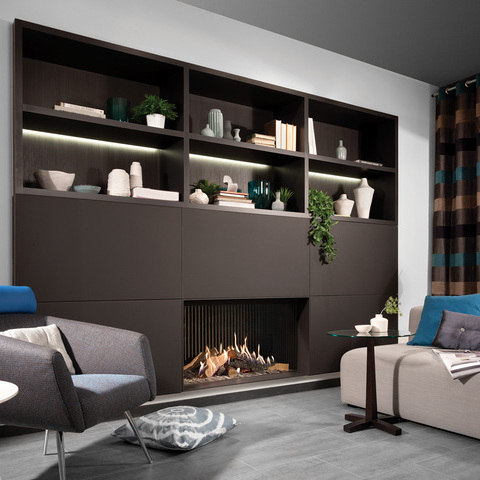 Cheminée à gaz GP105/59F avec vitre frontale intégrée dans un mur noir avec espace de rangement dans le salon confortable