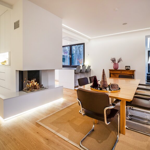 Gas fireplace GP70/55S glazed on 3-sided in white wall in dining room with parquet floor