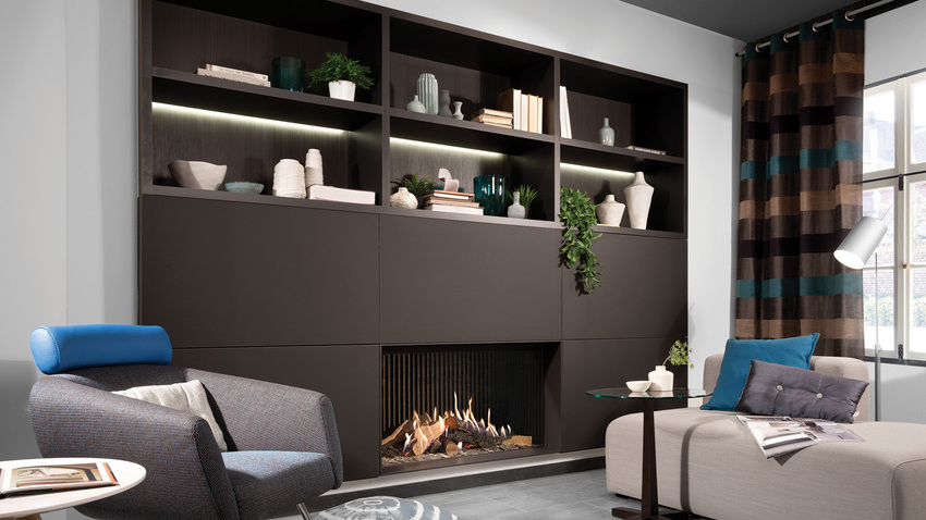 Gas fireplace GP105/59F with front glass built into black wall unit with storage space in the cosy living room