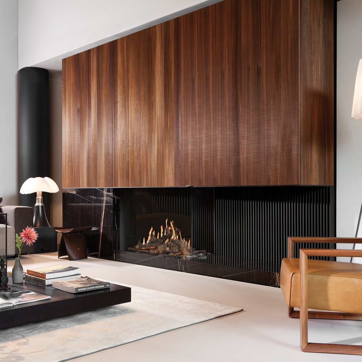 Gas fireplace GP110/55C 2-sided glazed with dark rear wall and wood panelling in modern living room with leather armchair