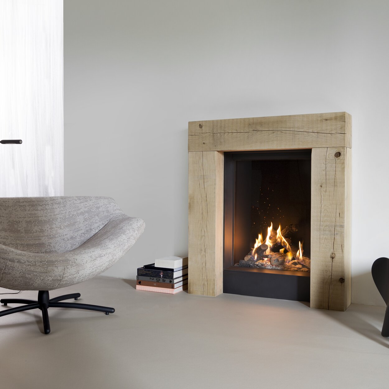 Front version gas fireplace GP60/79F with wooden frame built into white wall in living room with armchair