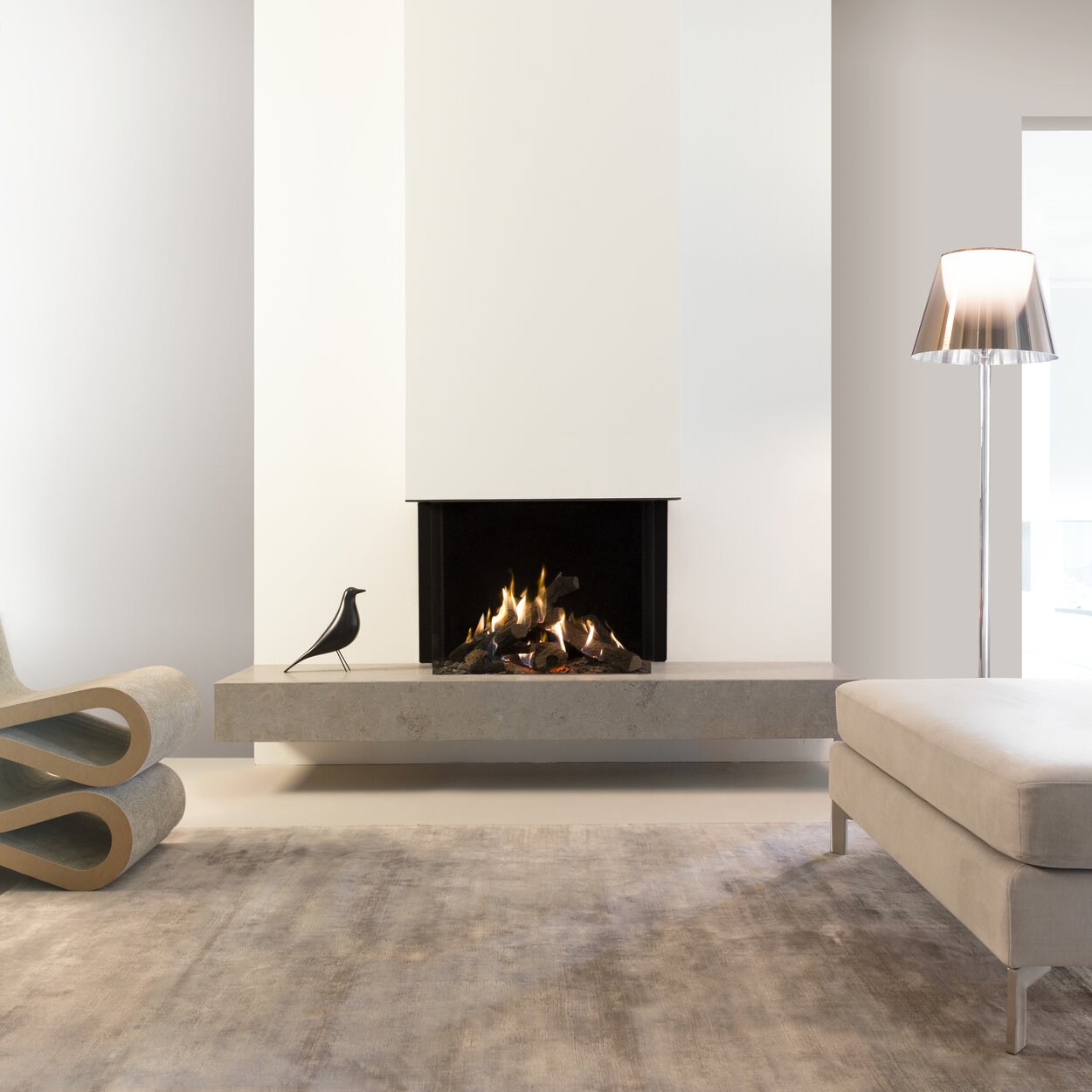 Gas fireplace GP70/55S glazed on 3 sides on a stone base in a white wall in the living room