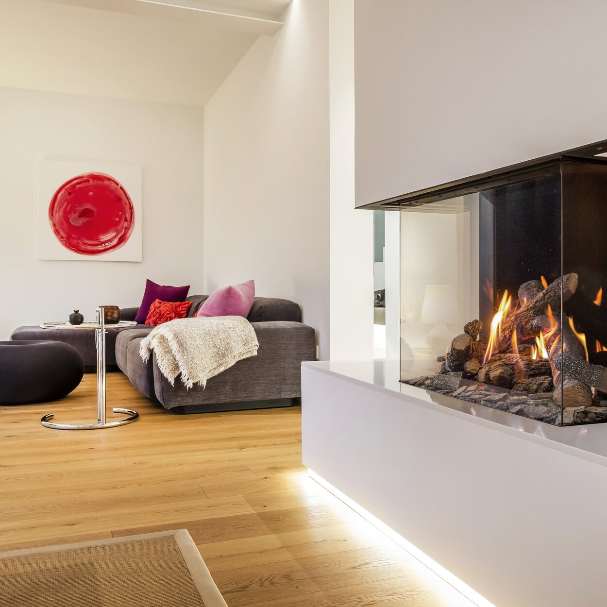 Gas fireplace GP70/55S glazed on 3-sided in bright living room with parquet floor built into white wall