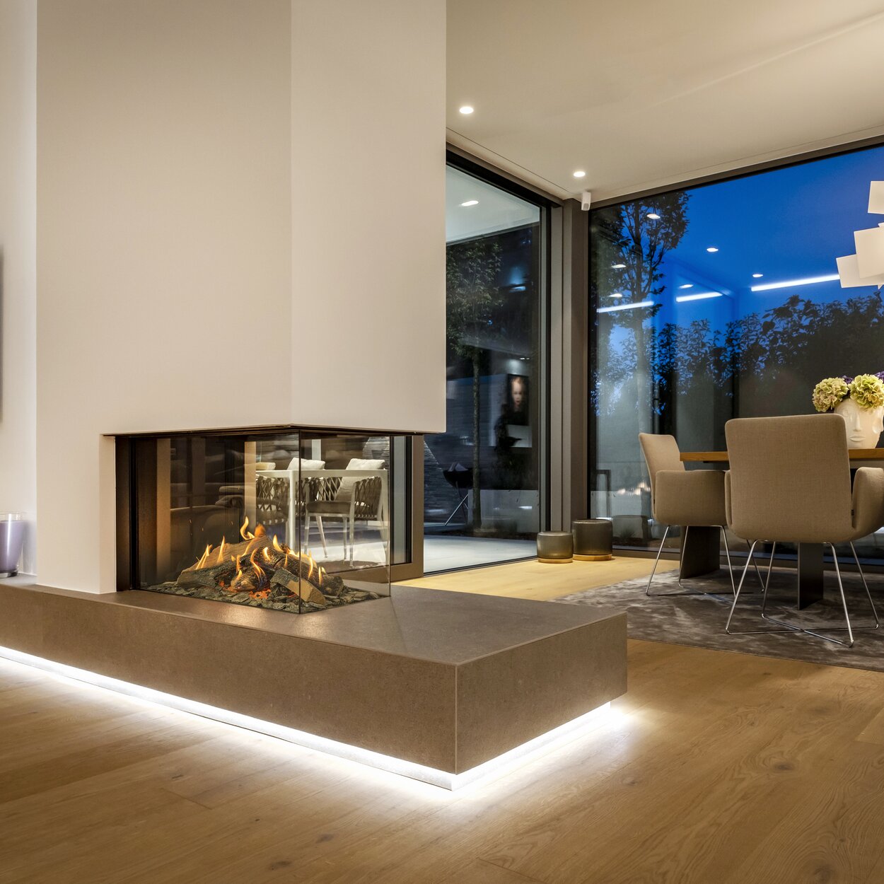 Gas fireplace GP85/50R as a room divider between living and dining room with parquet floor and evening atmosphere