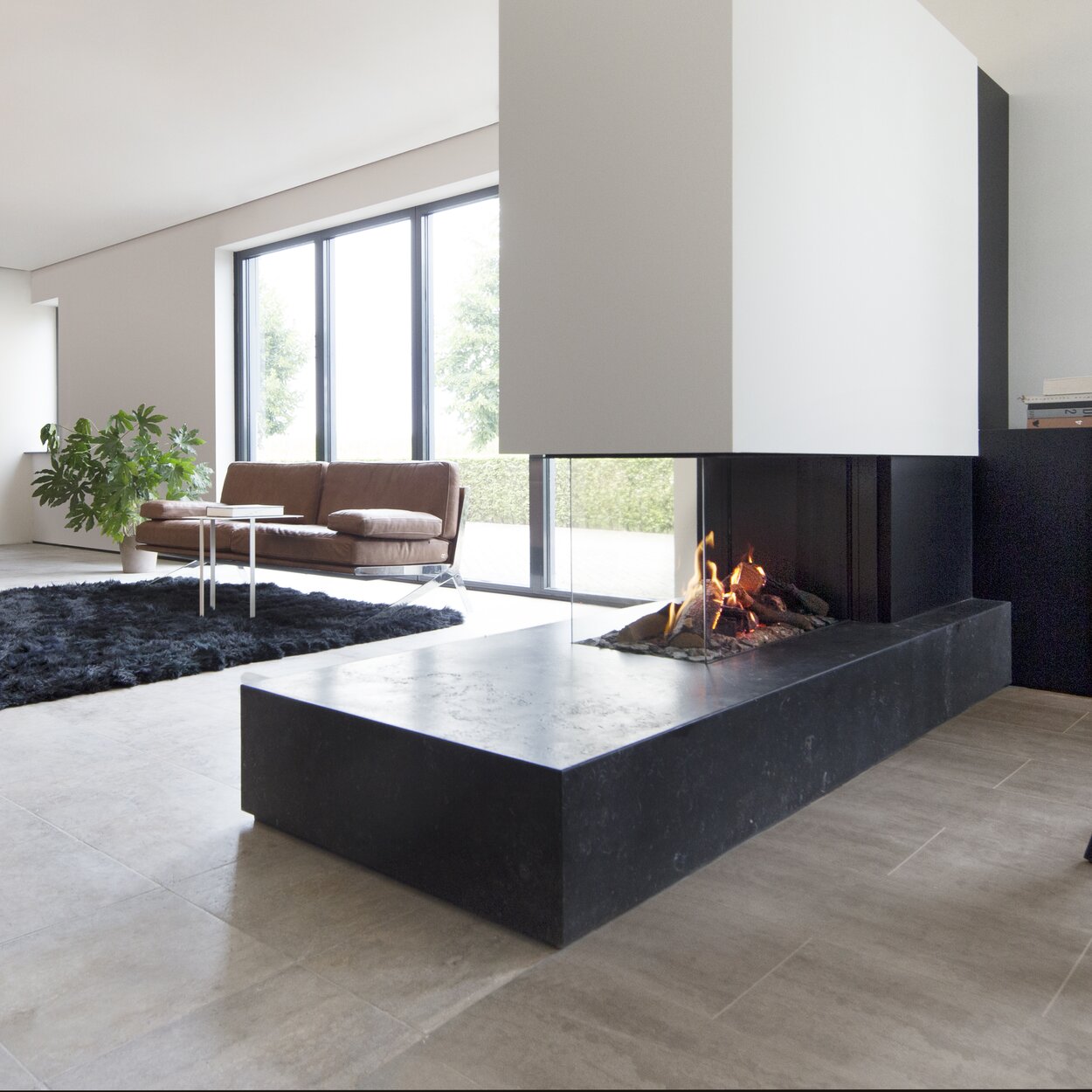Gas fireplace room divider GP85/50R on stone top and with white panelling in modern living room with parquet flooring