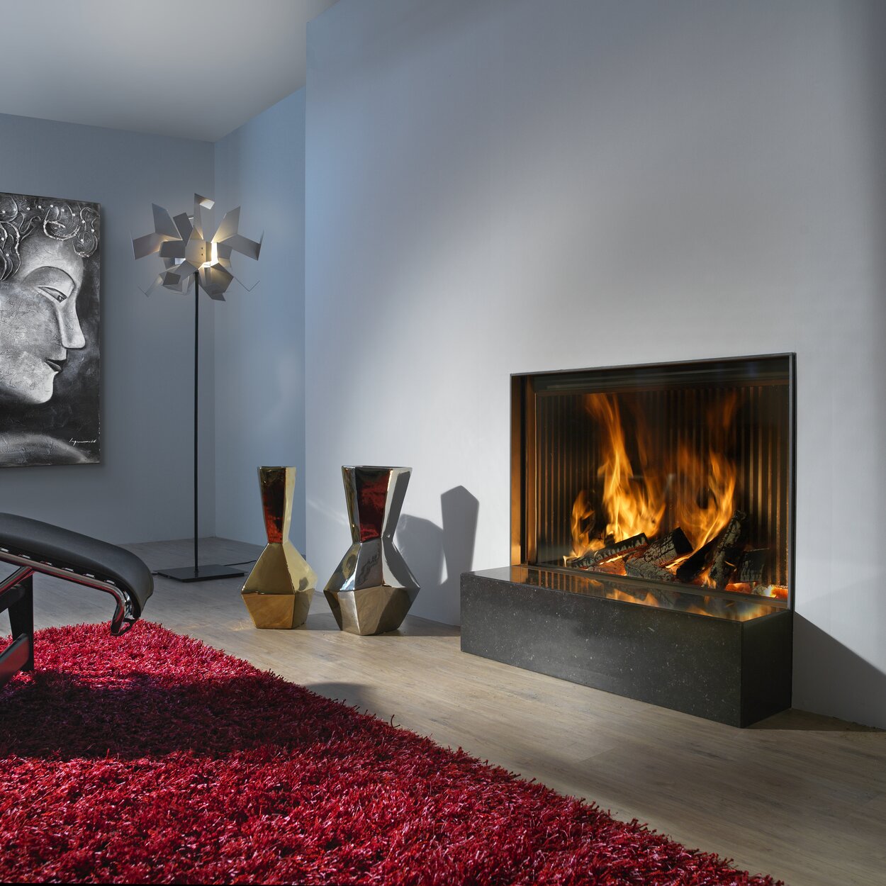 Camino a legna W100/61F di Kalfire in versione frontale nel soggiorno arredato artisticamente con tappeto rosso