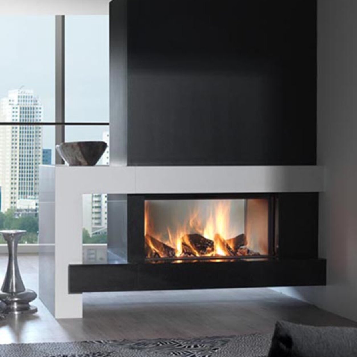 Wood fireplace W105/47T by Kalfire as tunnel version is located between the couch and the large window front with a view of the city
