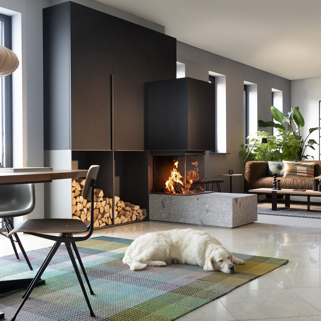 Wood fireplace W53/50R Room divider by Kalfire as a 3-sided fireplace that stylishly separates the living room from the dining room and a sleeping dog