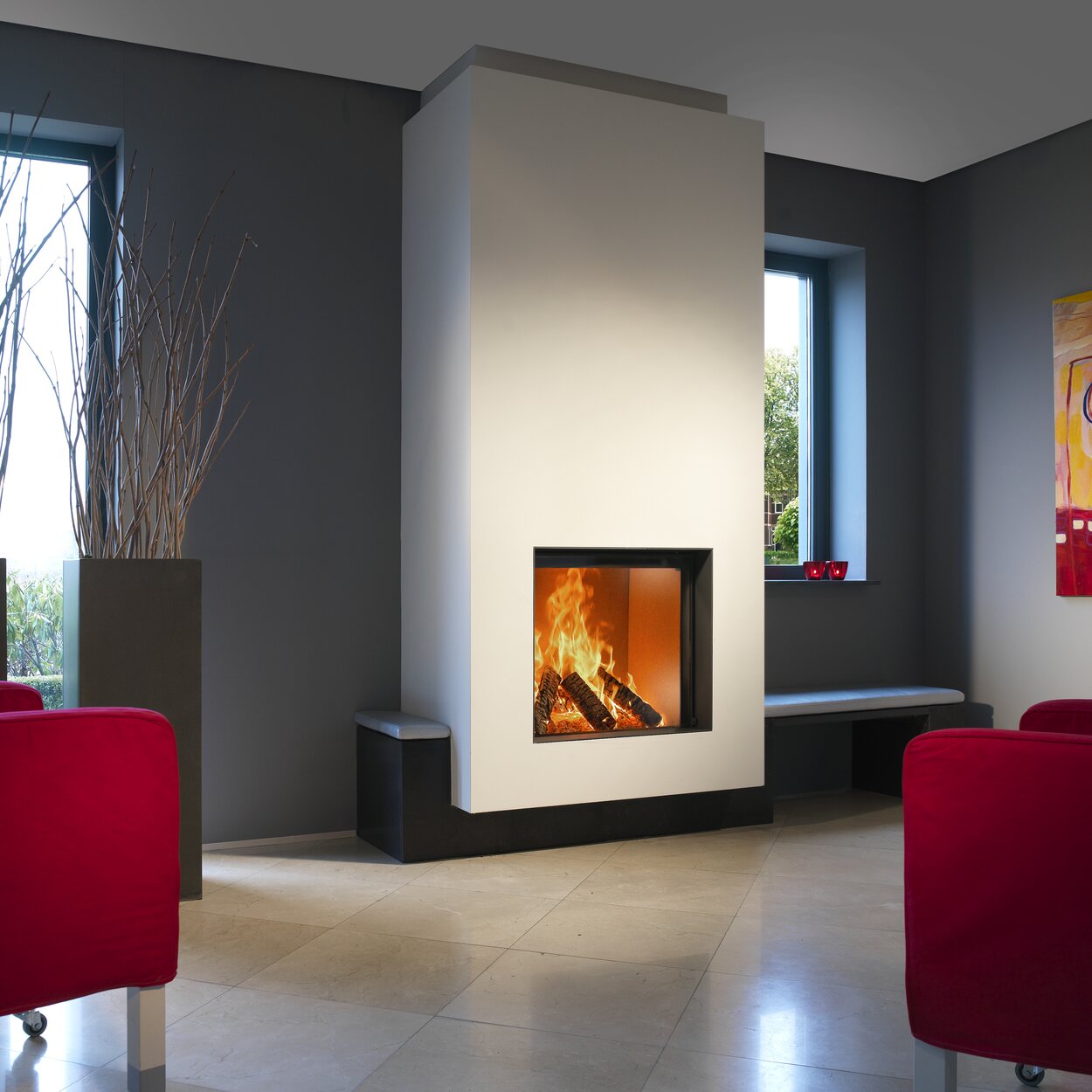 Wood fireplace W71/62F by Kalfire integrated into a white wall in a modern living room with grey walls and red furniture