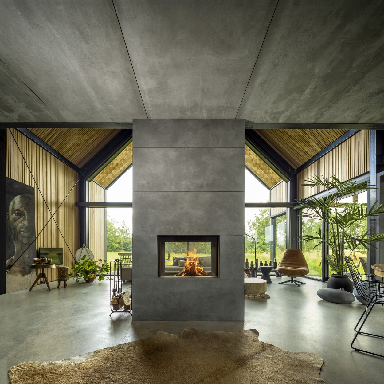 Wood fireplace W80/52T by Kalfire as the centre of the house with natural furnishings and a view of the natural surroundings through the tunnel fireplace